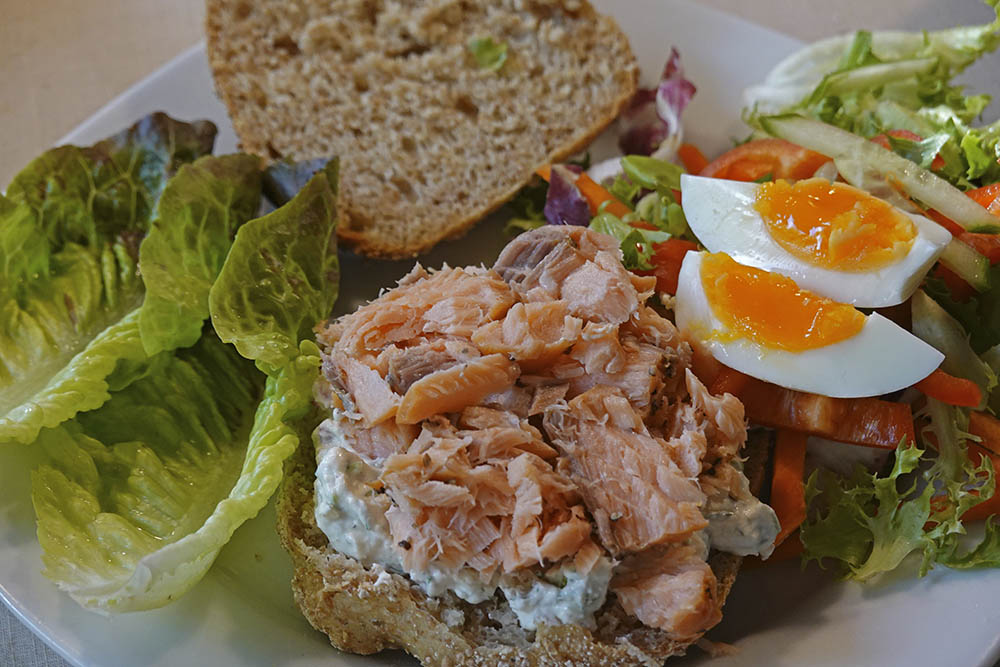 Grovbolle med rygeostcreme, varmrøget laks og bindsalat